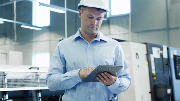 Ingenjör i hård hatt är med hjälp av Tablet Pc på fabriken — Stockvideo