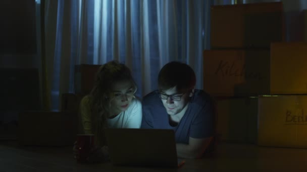 Casal jovem está usando laptop à noite . — Vídeo de Stock