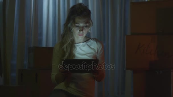 Menina está usando Tablet na nova casa à noite — Vídeo de Stock