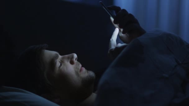 L'homme utilise le téléphone au lit — Video