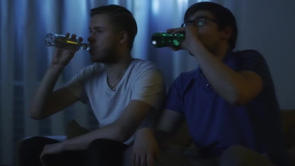 Amigos están viendo televisión y bebiendo cerveza por la noche — Vídeo de stock