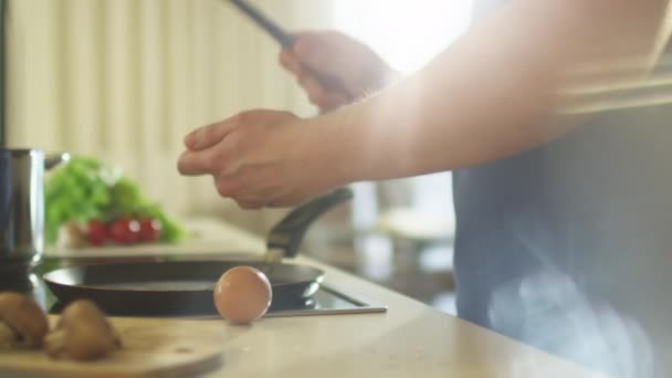 Mann knackt Eierschale für die Zubereitung von Spiegeleiern am Morgen — Stockvideo