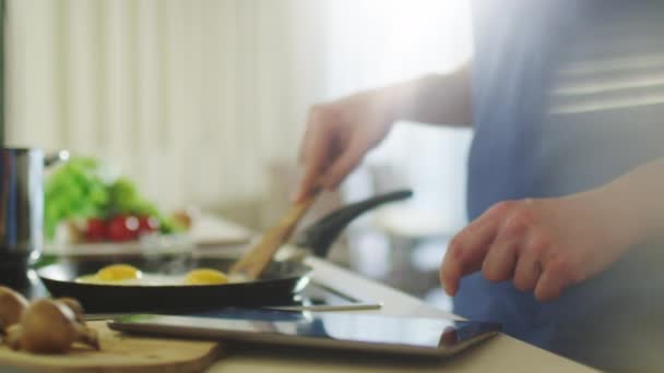 Man is Using Tablet PC While Preparing Food — Stock Video