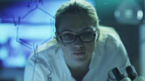 A tudós nő rajz szerves kémiai képletek üveg. Golyó piros mozi kamera 4 k (Uhd). — Stock videók