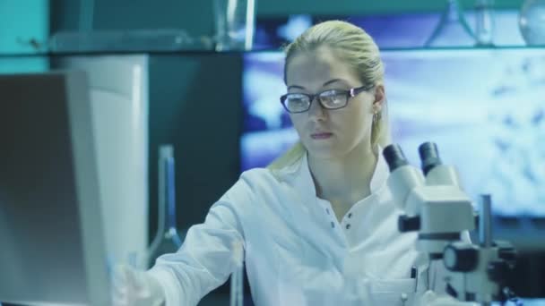 Mulher cientista em óculos faz pesquisa química e usando microscópio — Vídeo de Stock