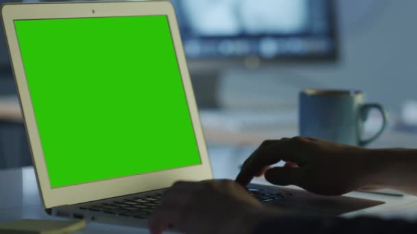 Προγραμματιστής εργάζεται στο γραφείο σε φορητό υπολογιστή με πράσινη οθόνη για μακέτα — Αρχείο Βίντεο