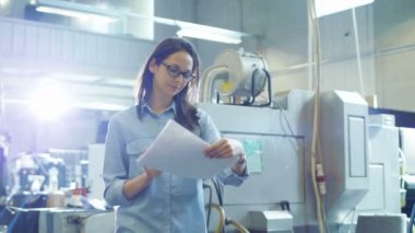 Kadın mühendis fabrika belgelerle size yürür.