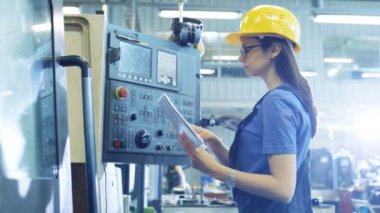 Sabit şapka ortamda profesyonel kadın operatör yukarı / programlama Cnc makine ile Denetim Masası büyük bir Sanayi Fabrikası'nda.