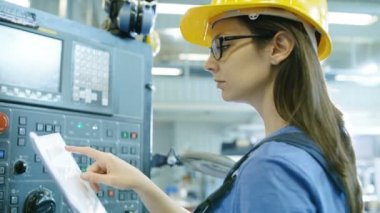 Sabit şapka ortamda profesyonel kadın operatör yukarı / programlama Cnc makine ile Denetim Masası büyük bir Sanayi Fabrikası'nda.
