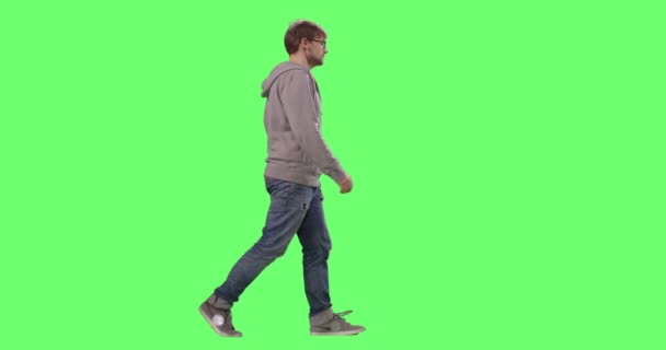 Neformální mladý dospělý chůzi na pozadí zelené obrazovky maketa. — Stock video