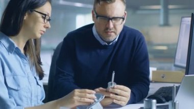 Erkek Şef Mühendis muayenelere bileşen dayanıklılık hakkında kadın teknisyeni ile. Bilgisayar ekran gösterir 3d tasarlanmış türbin / motor bölümü.