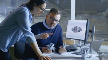 Kadın sanayi teknisyen ve erkek Şef Mühendis 3d türbin tasarımı / motor modeli Cad yazılım yardımı ile. Bir bilgisayar ile iki göstermek üzerinde çalışırlar. 