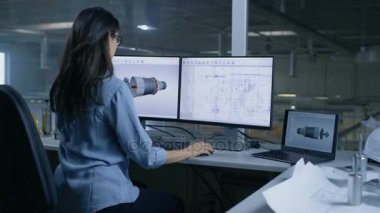 3d modeli bir türbin veya motor bölümü bir şef erkek mühendis tasarımlar. İkinci monitör teknik planları gösterir. Ofis pencere büyük fabrika dışında görülür.