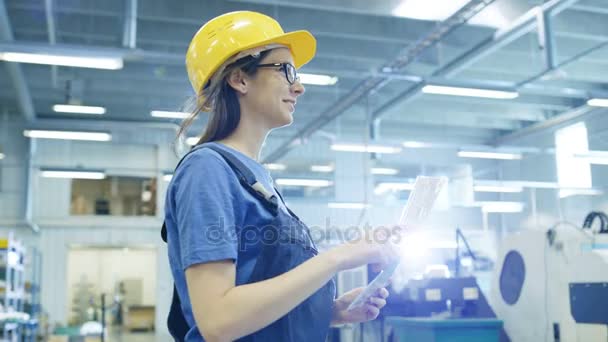 Krásné ženské průmyslové dělníky chodí a čte dokumenty v téže složce velký tovární budovy. — Stock video