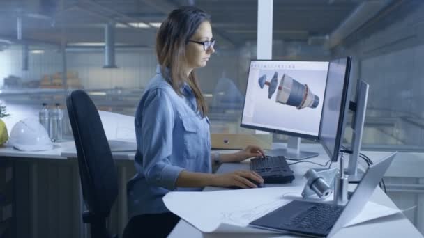 Female Industrial Engineer conçoit une turbine / un moteur 3D avec logiciel informatique. L'intérieur de l'usine est vu de sa fenêtre de bureau . — Video