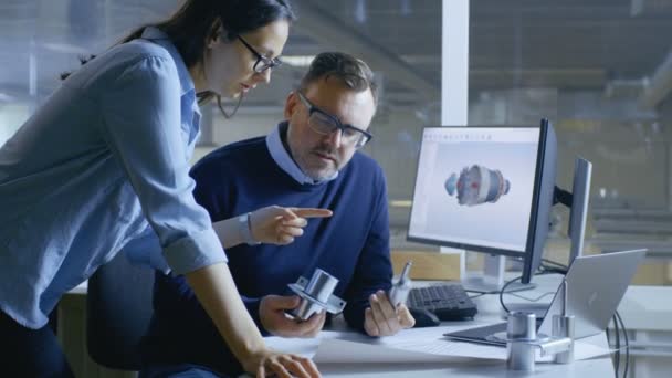 Technicienne industrielle et ingénieure en chef Concevoir un modèle de turbine / moteur 3D à l'aide du logiciel Cad. Ils travaillent sur un ordinateur avec deux affichages . 