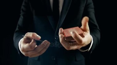 Bir sihirbaz Close-Up performanslı kart numarası eller. Hava atma ve yakalama kartları güverte. Arka plan siyahtır. Ağır çekim.