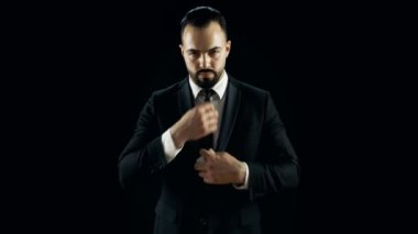 Siyah bir takım elbise içinde profesyonel sihirbaz kart yaslama değişiklik numarası yapar. El çabukluğu. Arka plan siyahtır.