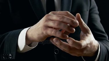 Bir sihirbaz Close-Up performanslı kart numarası eller. Atma ve kartlar havada yakalamak. Arka plan siyahtır. Ağır çekim.