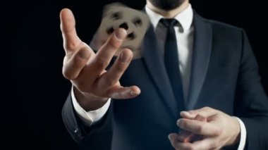 Yakın çekim el çabukluğu kart numaraları, performans uygun bir büyücü el Fan bir parmak bir kart iplik kartları, dışarı. Arka plan siyahtır.