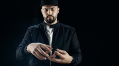 Bir kap içinde profesyonel sokak büyücü el çabukluğu kart numaraları gerçekleştirir. Arka plan siyahtır.