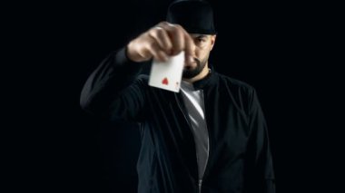 Profesyonel sokak büyücü bir kap içinde etkileyici el çabukluğu kart numarası yapar. Arka plan siyahtır.