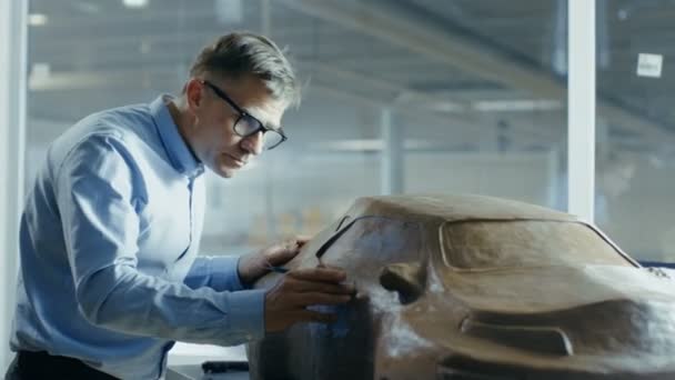 Capo Designer Automotive con Rake Sculpts Futuristic Modello auto da Plasticine Clay. Lavora in uno studio speciale situato in una grande fabbrica di auto . — Video Stock