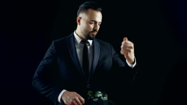 Professional Magician Performs Flower (Rose) Bud Disappearing and Appearing Spectacular Trick. The Background is Black. — Stock Video