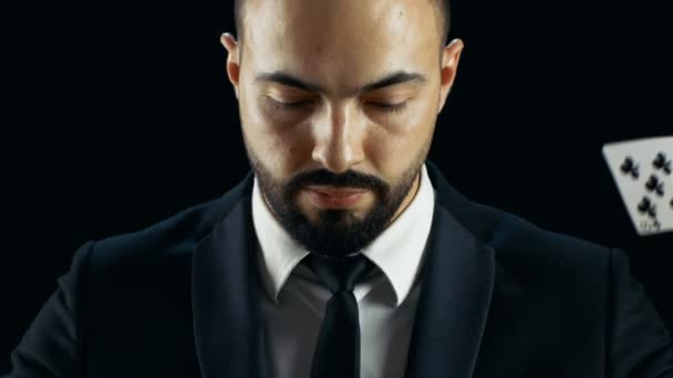 Close-up πορτρέτο της γενειοφόρος άνδρας κοιτάζοντας την κάμερα και κάρτες Gaming βρέχει σ ' αυτόν σε αργή κίνηση. — Αρχείο Βίντεο