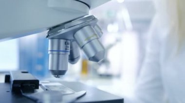 Yakın çekim Shot mikroskop arıyorsunuz bir tıbbi araştırma bilim adamı. Modern ve parlak laboratuvardır.