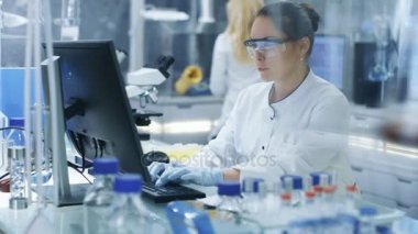 Yeni deneysel ilaç mahkemeden alınan bilgilerini yazarak tıbbi araştırma bilim adamı. O parlak ve Modern laboratuvar çalışıyor.