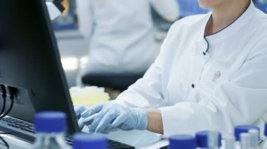 Tıbbi araştırma bilim adamı iş üstünde özel bilgisayar. O bir Modern parlak laboratuarında çalışıyor.