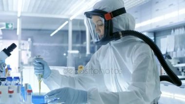 Tıbbi Viroloji araştırma bilim adamı bir Hazmat uygun maske ile çalışır, o Micropipette kullanır. O bir steril yüksek teknoloji Laboratuvarı, araştırma tesisi çalışır.