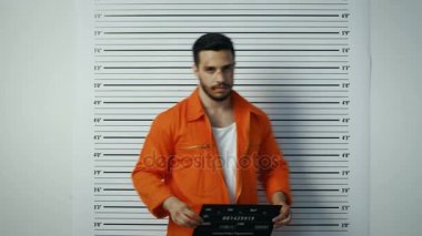 Bir polis karakolu, erkek mahkum, kadın suçlu ve genç suçlu birbiri ardına Mugshots için poz. Onlar her tasarlamak, bereli görünüyor tutun. Arka plan grafikte yükseklik.