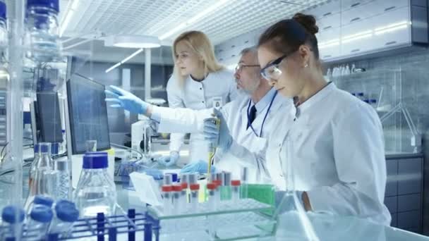 Team of Research Scientists Working With Personal Computer, Analysing Test Trial New Generation Drug Data. They Work in a Modern Laboratory/ Medical Center. — Stock Video