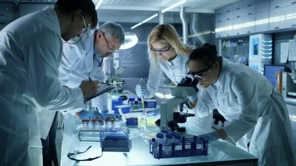 Orvosi kutatás tudósok egy új generációs kísérleti gyógyszeres kezelés együttesen dolgozik a csapat. Laboratóriumi néz elfoglalt, világos és Modern.