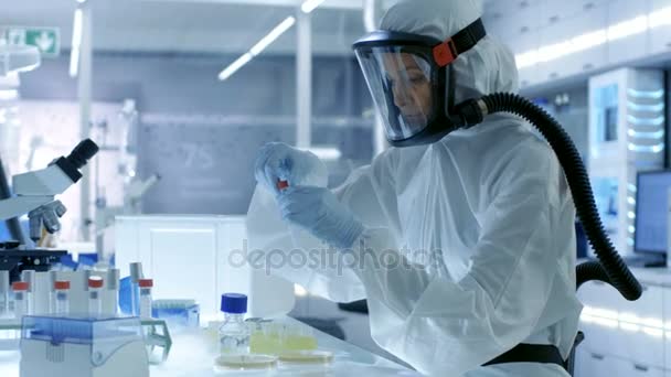 Medical Virology Research Scientist Works in a Hazmat Suit with Mask, She Uses Micropipette (dalam bahasa Inggris). Dia bekerja di Laboratorium Teknik Tinggi Sterile, Fasilitas Penelitian . — Stok Video