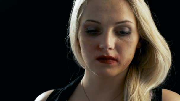 Close-up Shot Sad Crying Bruised Blonde Woman Looking Down e Then Into the Camera. Tema da violência. Tiro em fundo preto isolado . — Vídeo de Stock