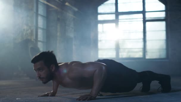 Μυώδης άνδρας Shirtless καλύπτονται στον ιδρώτα κάνει Push-ups σε ένα εγκαταλειμμένο εργοστάσιο που αναμορφώνονται σε γυμναστήριο. Μέρος του Σταυρού Γυμναστήριο προπόνηση υψηλής έντασης διάστημα κατάρτισης. — Αρχείο Βίντεο