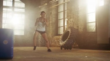 Uygun atletik kadın matkap salona Remodeled terkedilmiş bir fabrikada çalışan ayak hareketleri yapar. Fitness Egzersiz çapraz / egzersiz amaçlı bacaklar onun çeviklik ve hız arttırmak, güçlendirilmesi.
