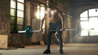 Güçlü atletik gömleksiz adam asansörleri ağır halter çapraz Fitness Eğitim rutin bir parçası olarak. Spor salonu yenilenmiş fabrikasında mı.