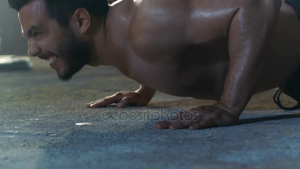 Close-up Shot of a Muscular Shirtless Man Atleta Fazendo Push-ups como parte de seu programa de exercícios de fitness Cruz. Ele está coberto de suor e trabalha numa fábrica deserta remodelada para o ginásio. . — Vídeo de Stock