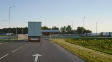 Takip Shot yarı kamyon kargo Trailer dönüm ile karayolu üzerinde sol. Ambar alanı boşaltma kargo kamyon gider. 