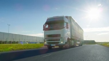 Büyük beyaz yarı kamyon kargo römork ile arka planda güzel bir gün ile sanayi bölgesi boş yolda hamle.