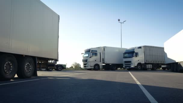 Camion bianco dei semi con il rimorchio del carico guida nel posto di parcheggio e parcheggia con altri veicoli . — Video Stock