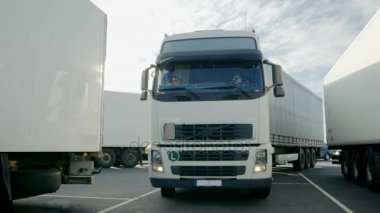 Park yeri ve diğer araç parkları içine beyaz yarı kamyon kargo römork ile Frontal View sürücüler.