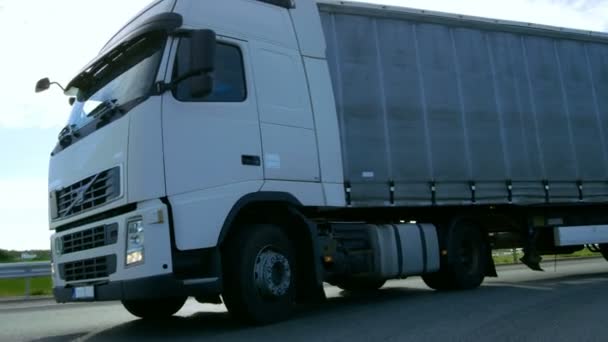 Vitesse semi-camion blanc avec remorque de fret tourne sur la route . — Video