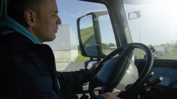 Wewnątrz kabiny widzenia zawodowego kierowcy jego duży pojazd na drodze. Magazyny przemysłowe są widoczne z okna. — Wideo stockowe