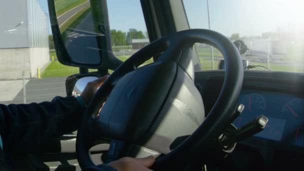 Binnenkant van de weergave van de cabine van de professionele vrachtwagenchauffeur zijn grote voertuig op de weg rijden. Industriële magazijnen worden gezien uit het raam. — Stockvideo