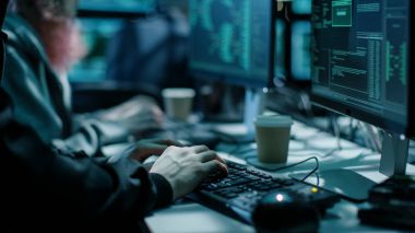 Yakın çekim Shot in klavye kullanarak Hacker. Kahve bardakları olduğunu ve